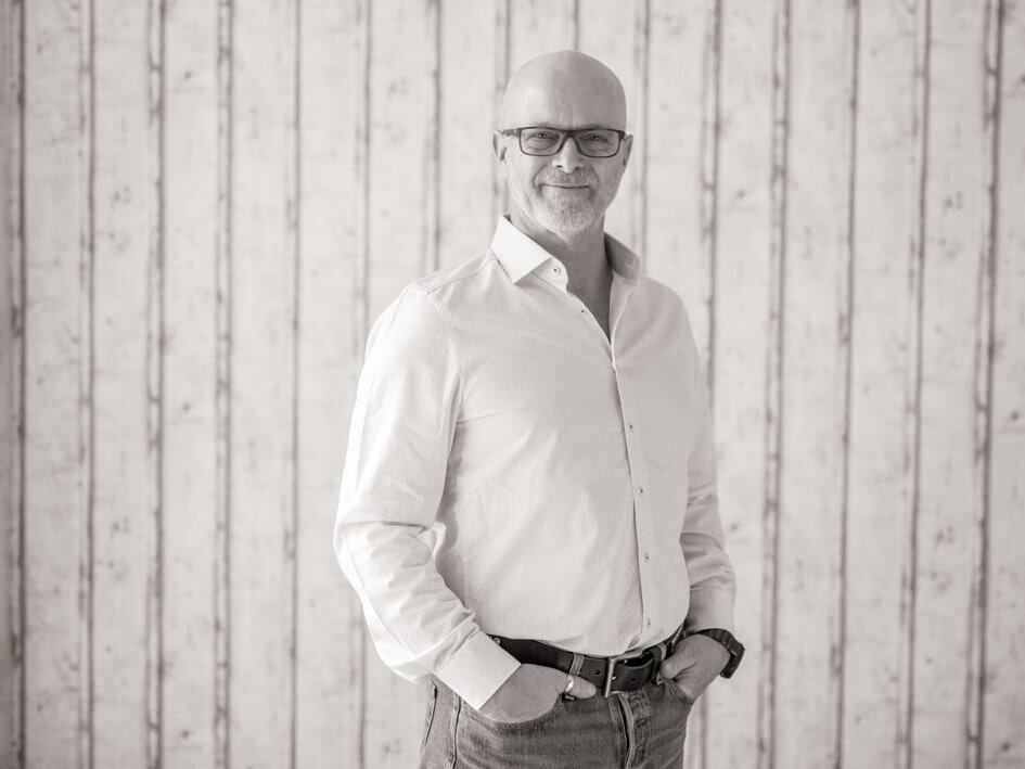 Mann in professioneller Kleidung vor Holzpaneel Wand, Selbstvertrauen, Erfolg und Erfolgskurs.