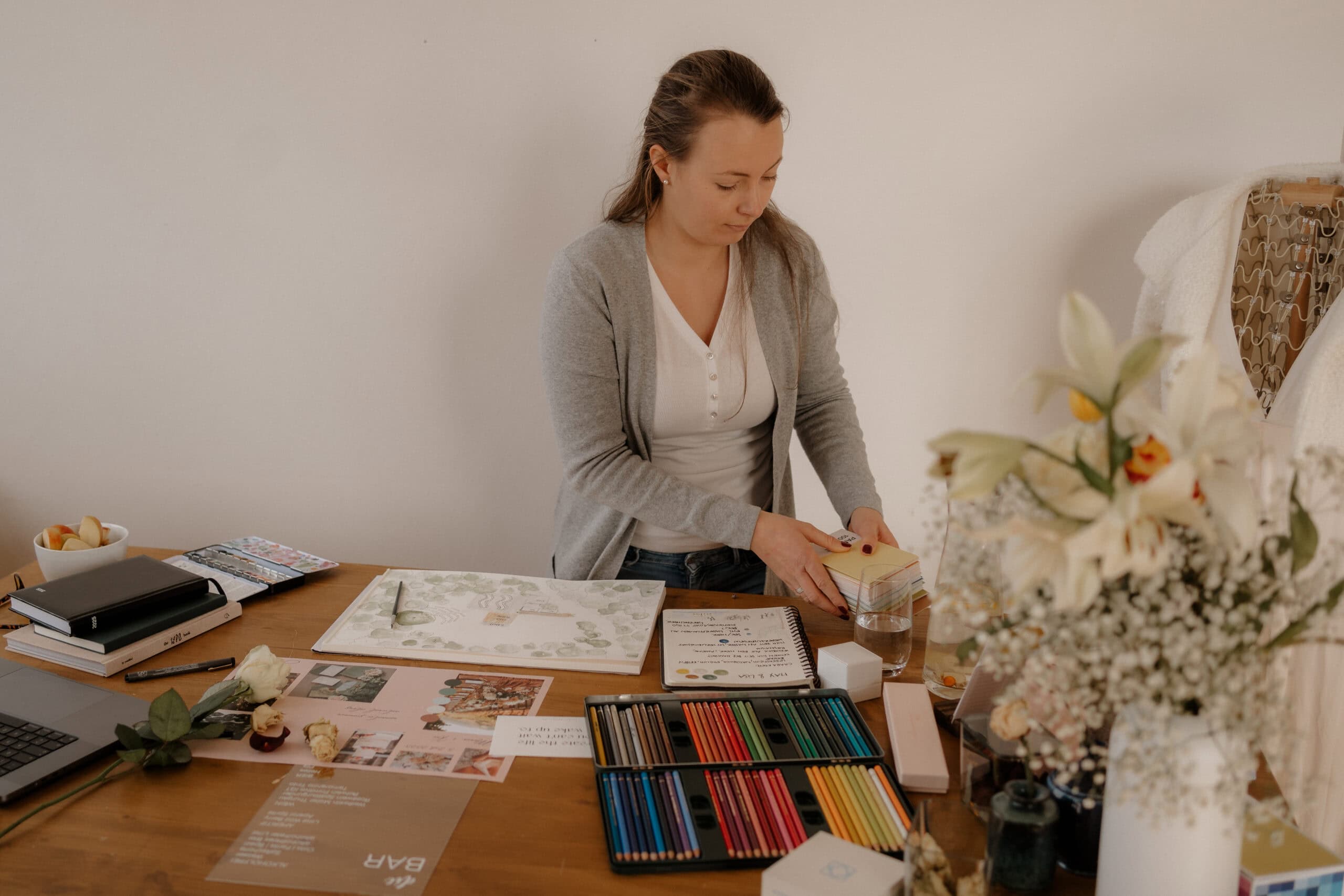 Farbenfrohes Kreativstudio mit Zeichenmaterial und Blumen.