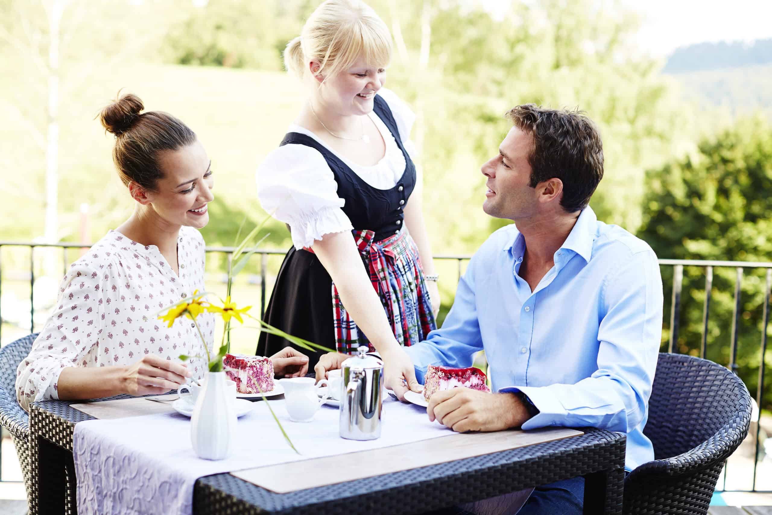 Fröhliche Menschen beim Frühstück im Grünen, ländliche Atmosphäre, Genuss, Gemeinschaft, gesunde Lebensweise.